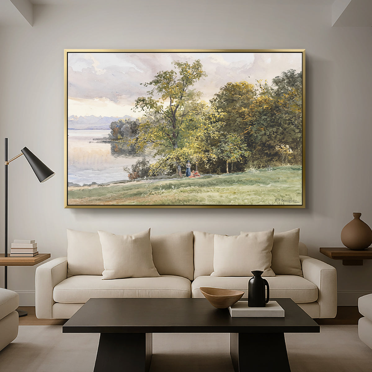 Landscape at Lake Starnberg, 1890 by Edward Theodore Compton as a gold floater framed canvas featuring a lakeside landscape with calm water and trees along shoreline, displayed above a sofa in a modern living room.