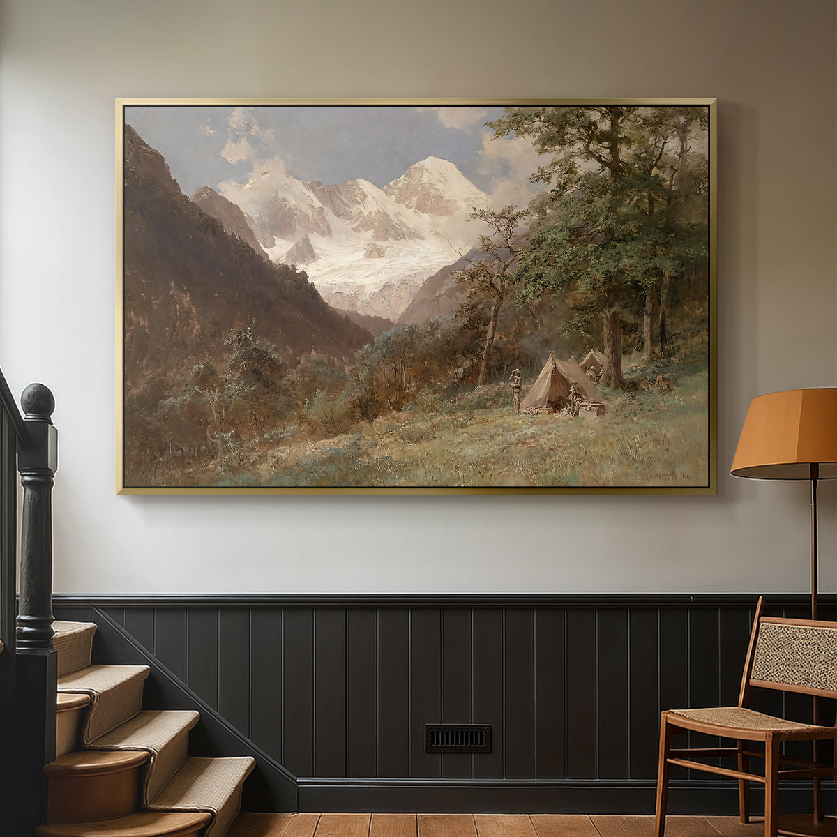 Gold floater framed canvas featuring a realistic depiction of remote mountain environment, displayed in a hallway near a staircase.