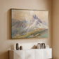Gold floater framed canvas of From the Dolomites, 1904 by Edward Theodore Compton, featuring an alpine scene with jagged rock formations and distant mountains above a console cabinet in a minimalist entryway.