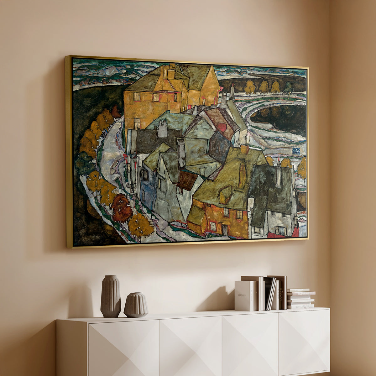 Gold floater framed canvas of Crescent of Houses II (Island Town), 1915 by Egon Schiele, featuring a stylized townscape with clustered buildings and bold outlines above a console cabinet in a minimalist entryway.