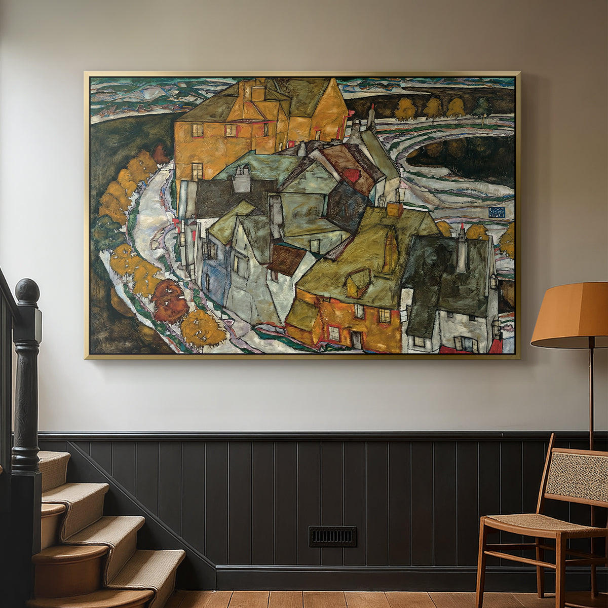 Gold floater framed canvas featuring an architectural scene with houses arranged in curved composition, displayed in a hallway near a staircase.