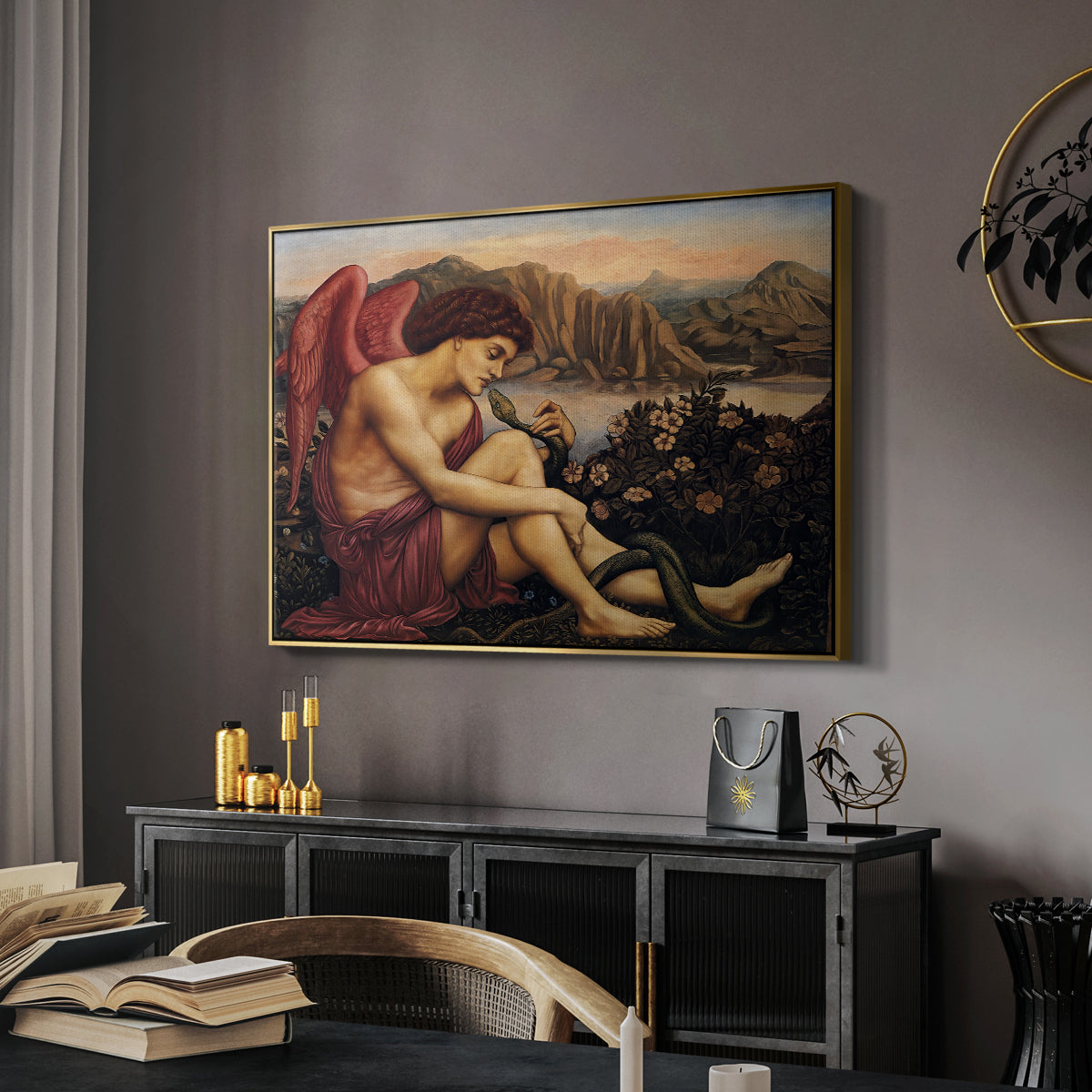 The Angel with the Serpent, c. 1870-1875 by Evelyn De Morgan in a gold floater framed canvas featuring a religious scene with angel defeating snake in dramatic pose, displayed above a desk in a dark home office interior.