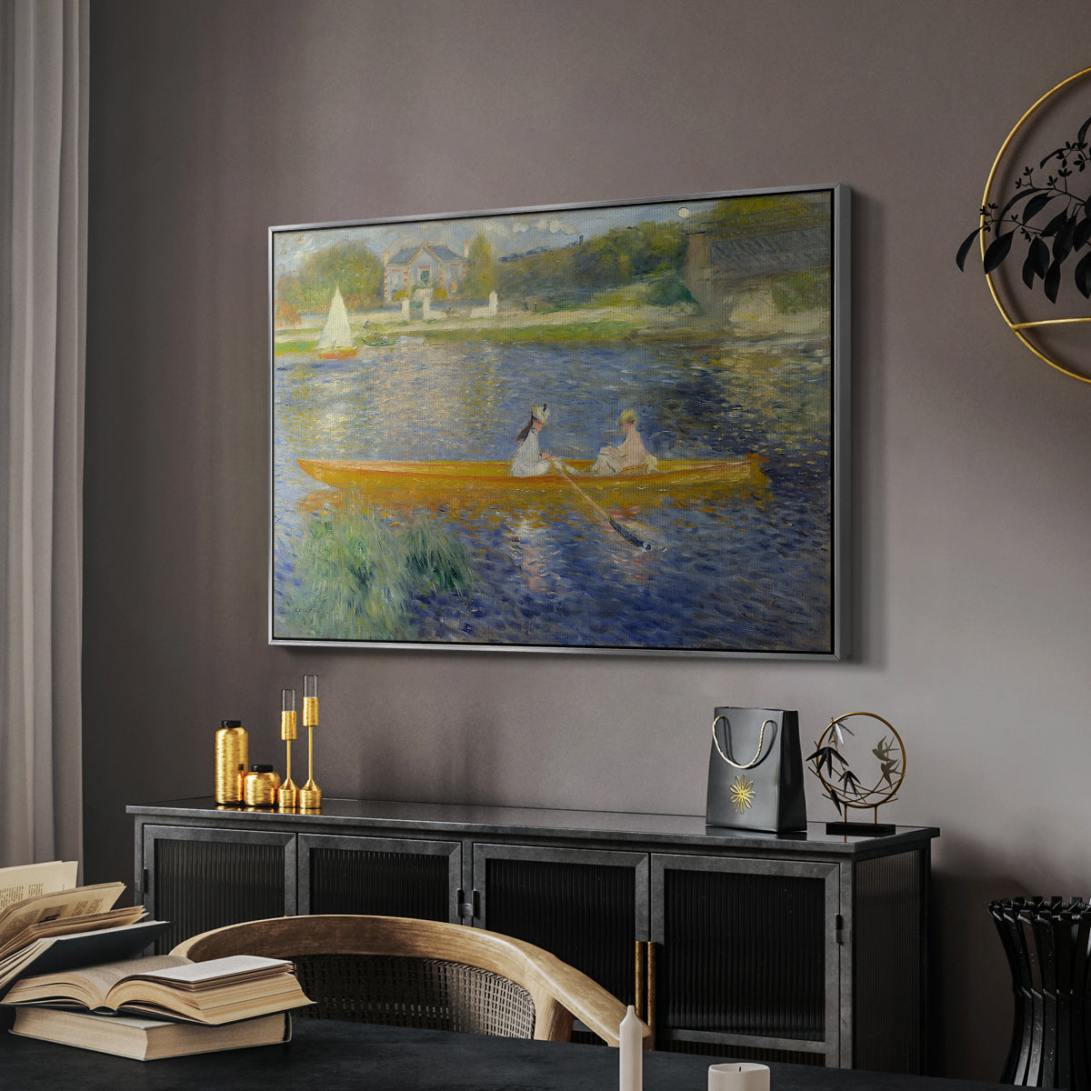 The Skiff (La Yole), 1875 by Pierre-Auguste Renoir in a silver floater framed canvas featuring a couple seated in boat on river surrounded by soft reflections, displayed above a desk in a dark home office interior.