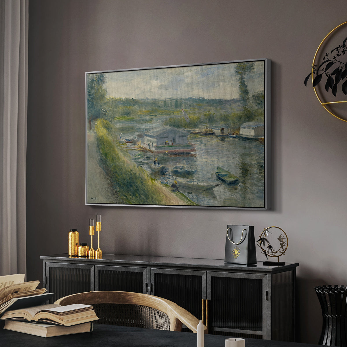 Wash-House Boat at Bas-Meudon, c. 1874 by Pierre-Auguste Renoir in a silver floater framed canvas featuring an impressionist depiction of working boat along calm waterway, displayed above a desk in a dark home office interior.