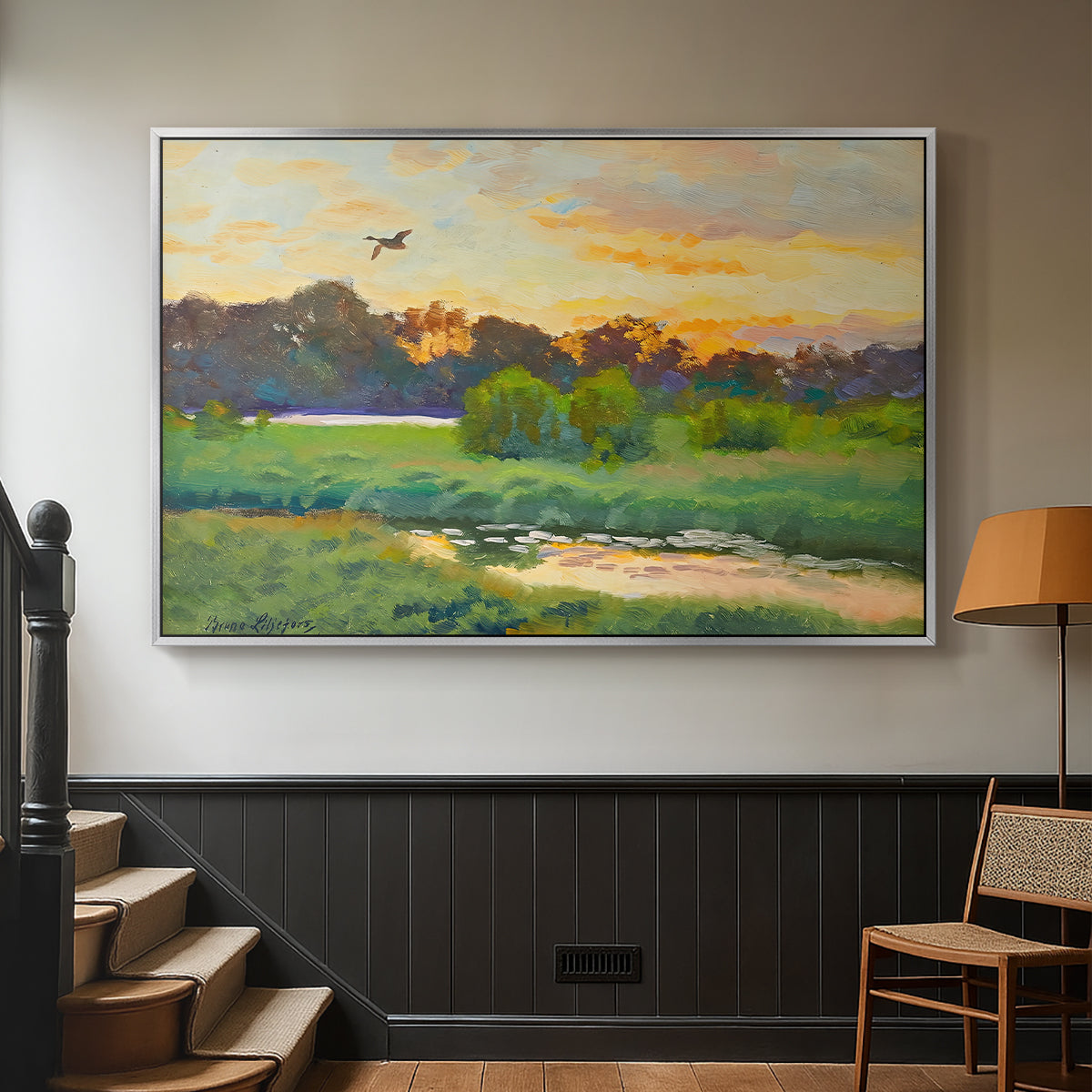 Silver floater framed canvas featuring a lone duck flying over a marsh at golden hour, displayed in a hallway near a staircase.
