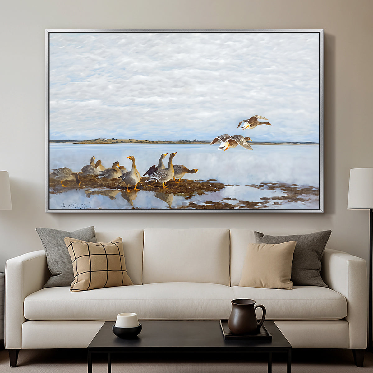 Greylag Geese (Grågäss), 1922 by Bruno Liljefors displayed in a silver floater framed canvas above a sofa in a clean living room.