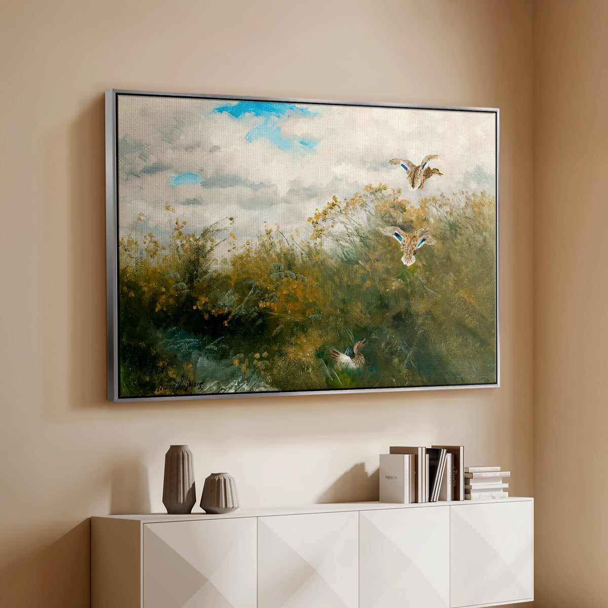 Silver floater framed canvas of Wild Ducks (Grasänder), 1890 by Bruno Liljefors, featuring a wildlife scene of ducks walking through tall grass beside water above a console cabinet in a minimalist entryway.