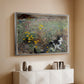 Silver floater framed canvas of Cat on a Flowery Meadow, 1887 by Bruno Liljefors, featuring a small cat resting among colorful flowers in grassy field above a console cabinet in a minimalist entryway.