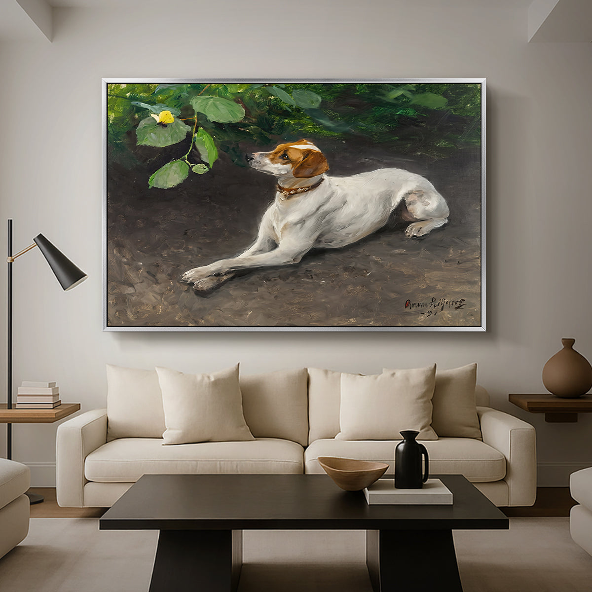 Portrait of a Dog, 1891 by Bruno Liljefors as a silver floater framed canvas featuring a dog lying on ground with head raised in natural outdoor setting, displayed above a sofa in a modern living room.