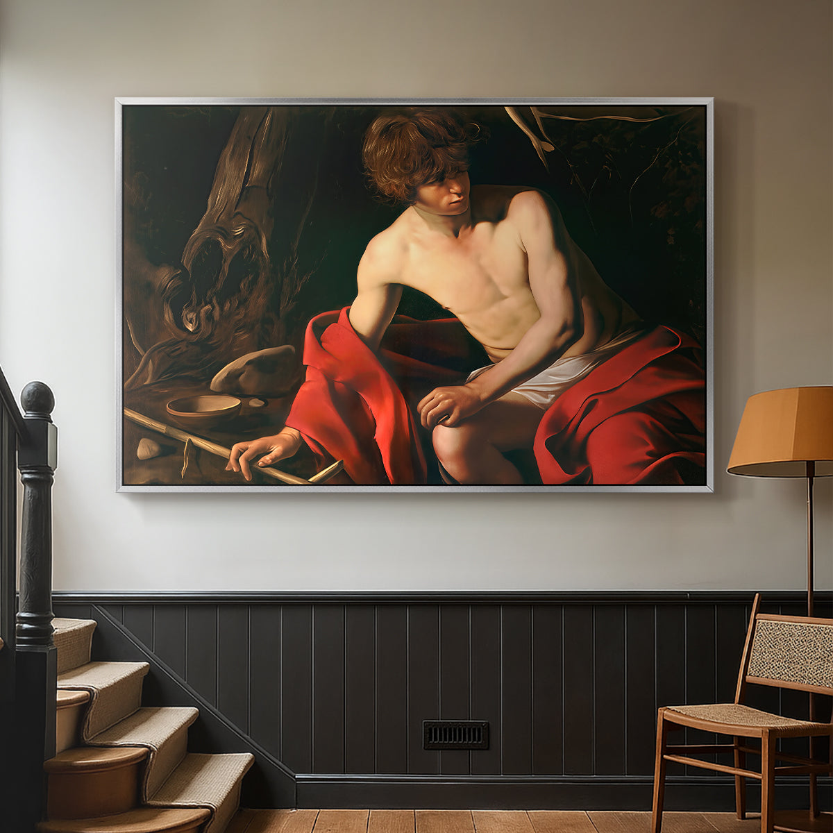 Silver floater framed canvas featuring a contemplative religious figure in rustic wilderness environment, displayed in a hallway near a staircase.
