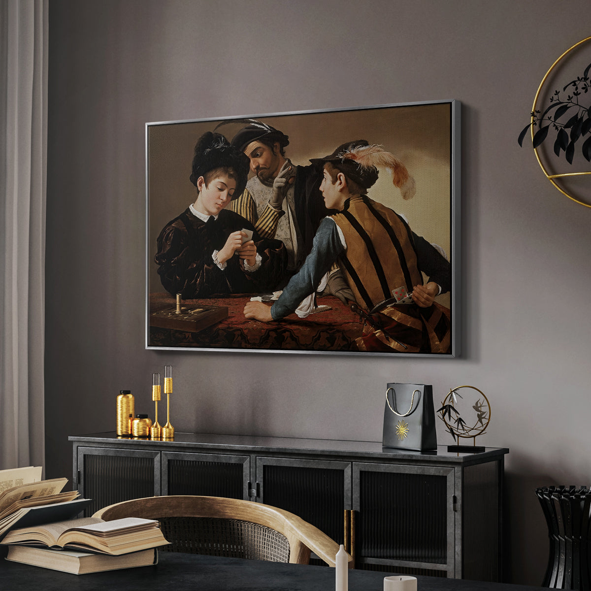 The Cardsharps, c. 1594 by Caravaggio in a silver floater framed canvas featuring a young men playing cards with one cheating and another watching closely, displayed above a desk in a dark home office interior.