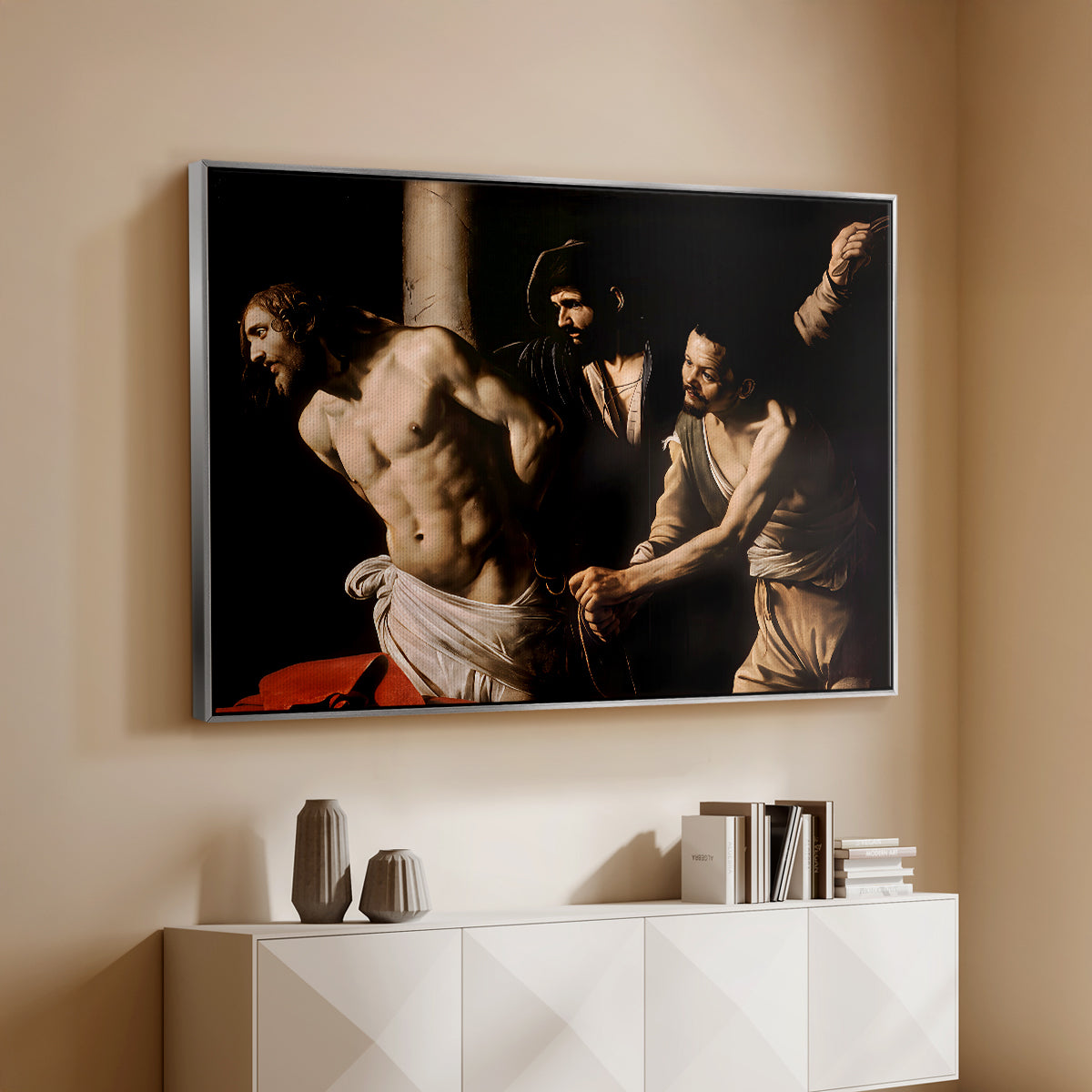 Silver floater framed canvas of The Flagellation of Christ at the Column (Rouen Version), 1606 by Caravaggio, featuring a dramatic religious scene of Christ enduring flagellation in dark interior above a console cabinet in a minimalist entryway.