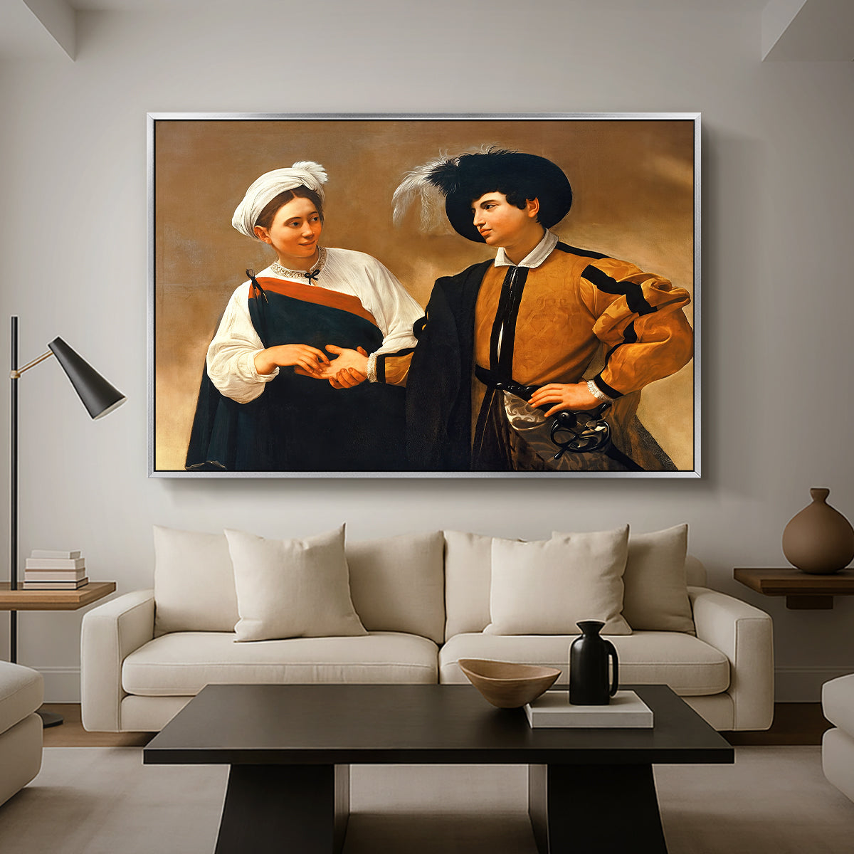 The Fortune Teller (Capitoline Version), c. 1599 by Caravaggio as a silver floater framed canvas featuring a woman reading man's palm while discreetly removing his ring, displayed above a sofa in a modern living room.