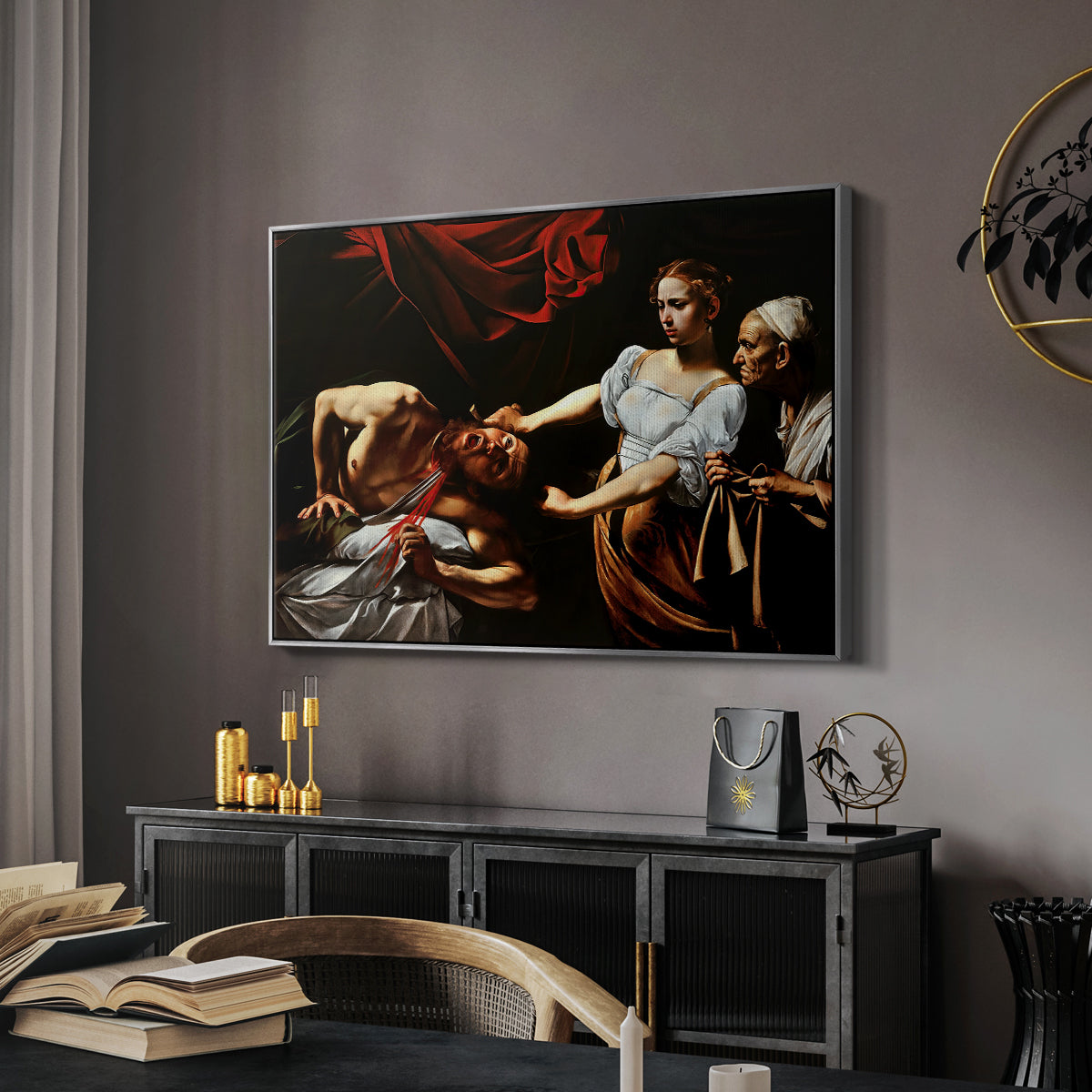 Judith Beheading Holofernes, c. 1599 by Caravaggio in a silver floater framed canvas featuring an intense moment of Judith slaying Holofernes with sword, displayed above a desk in a dark home office interior.