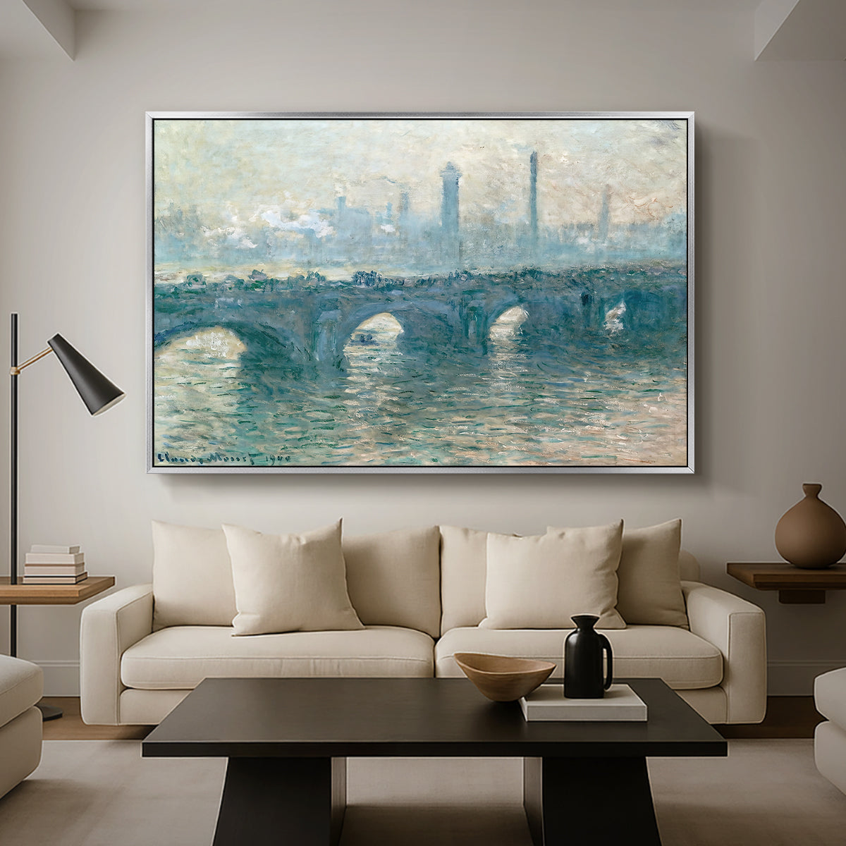 Waterloo Bridge, Gray Weather, 1900 by Claude Monet as a silver floater framed canvas featuring a hazy view of Waterloo Bridge over river in gray atmospheric light, displayed above a sofa in a modern living room.