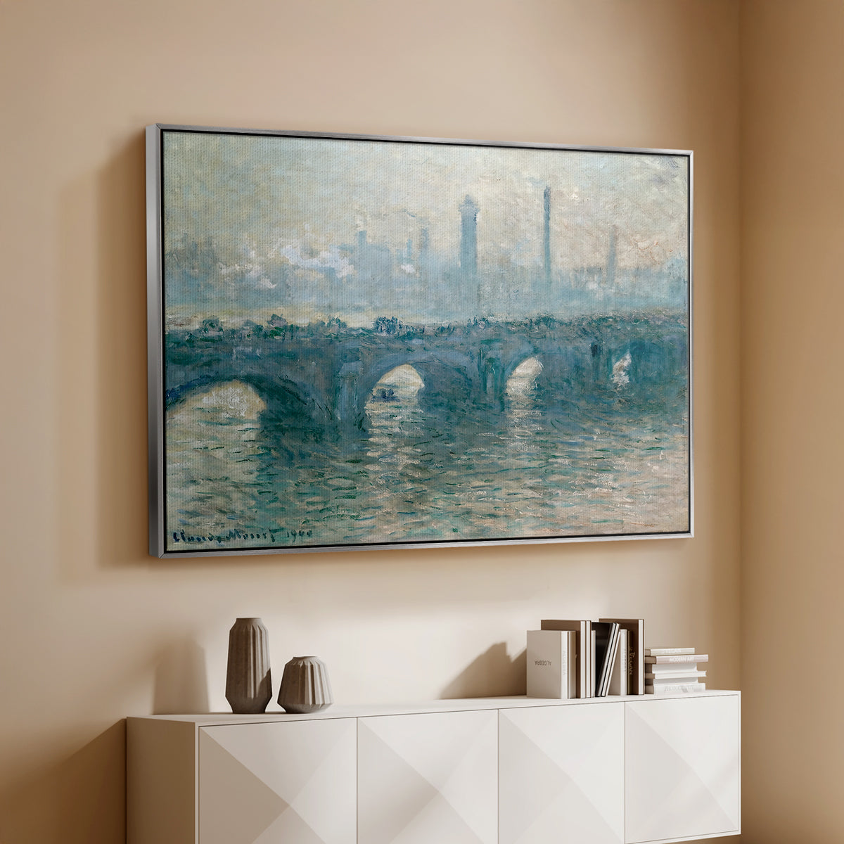 Silver floater framed canvas of Waterloo Bridge, Gray Weather, 1900 by Claude Monet, featuring an impressionist cityscape with bridge fading into fog over water above a console cabinet in a minimalist entryway.
