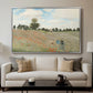The Poppy Field near Argenteuil, 1873 by Claude Monet displayed in a silver floater framed canvas above a sofa in a clean living room.