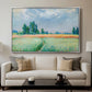 The Wheat Field (Champ de Blé), 1881 by Claude Monet displayed in a silver floater framed canvas above a sofa in a clean living room.