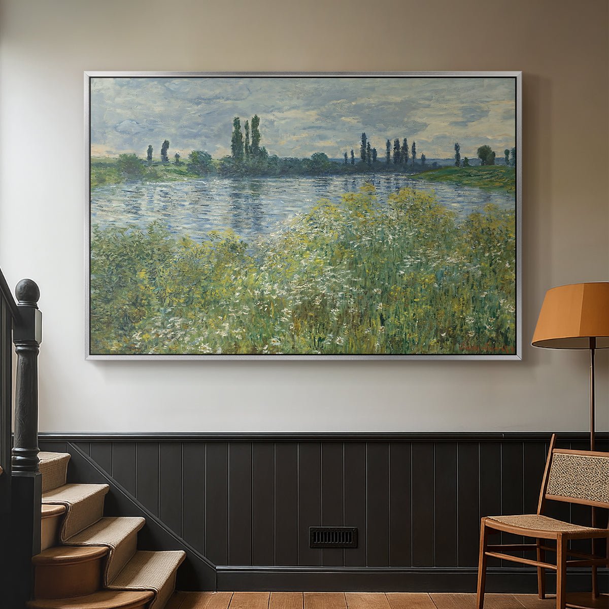 Silver floater framed canvas featuring a natural landscape with calm water and soft foliage, displayed in a hallway near a staircase.