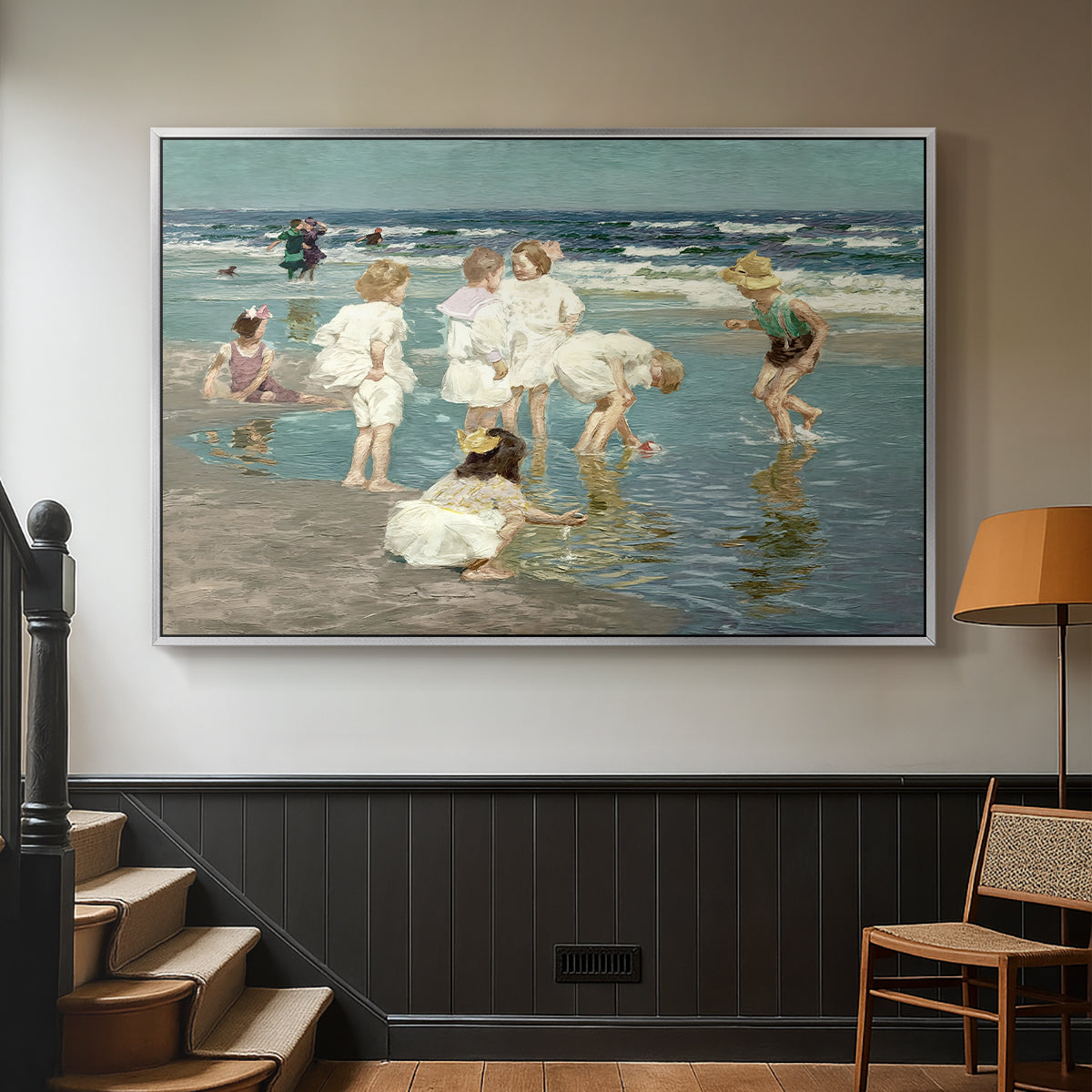 Silver floater framed canvas featuring a lively shoreline scene with people gathered in surf, displayed in a hallway near a staircase.