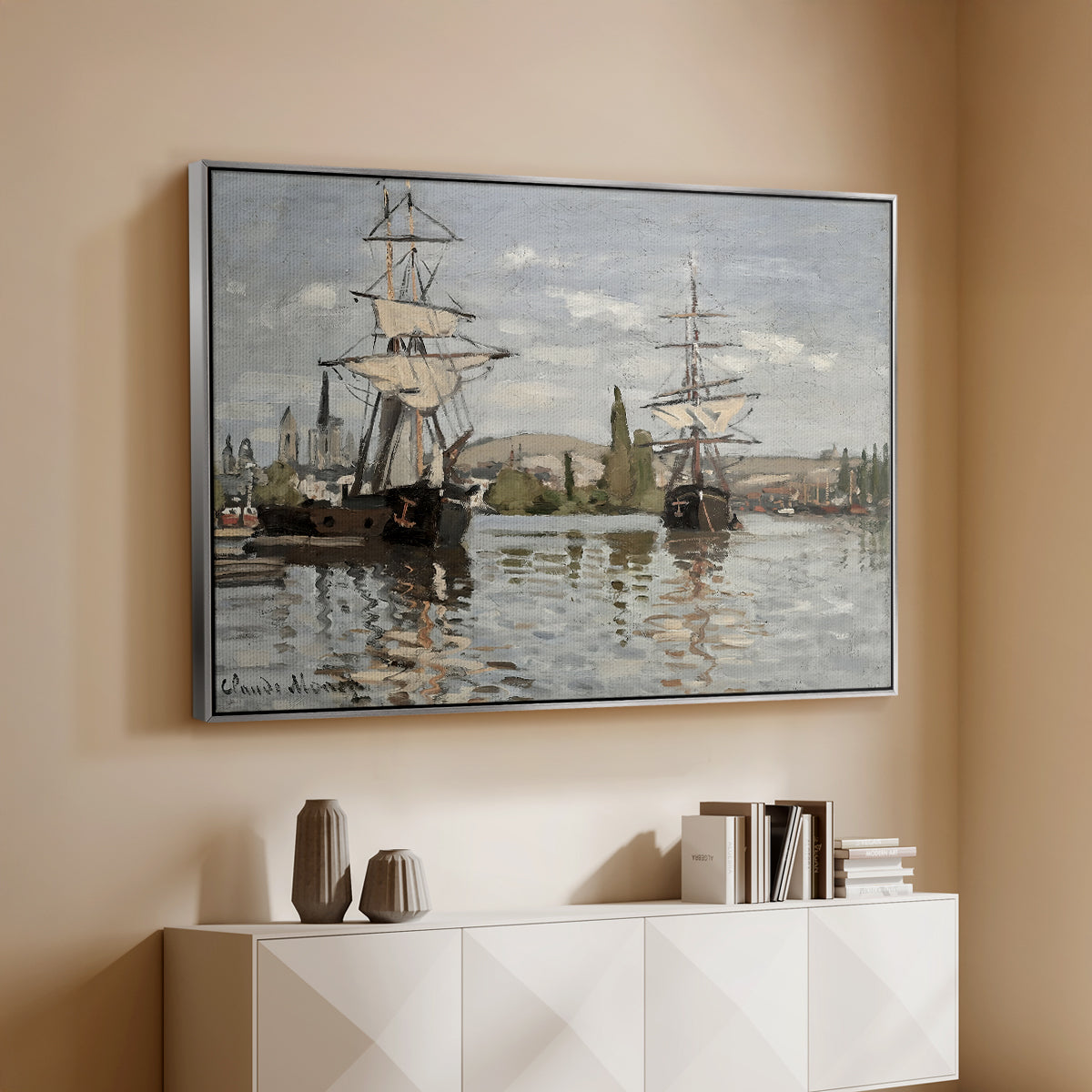 Silver floater framed canvas of Ships Riding on the Seine at Rouen, 1872 by Claude Monet, featuring an impressionist river scene with anchored sailing ships and reflections above a console cabinet in a minimalist entryway.