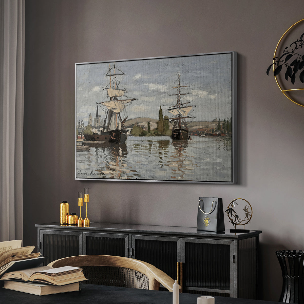 Ships Riding on the Seine at Rouen, 1872 by Claude Monet in a silver floater framed canvas featuring a harbor view with tall ships lining the waterfront in muted tones, displayed above a desk in a dark home office interior.
