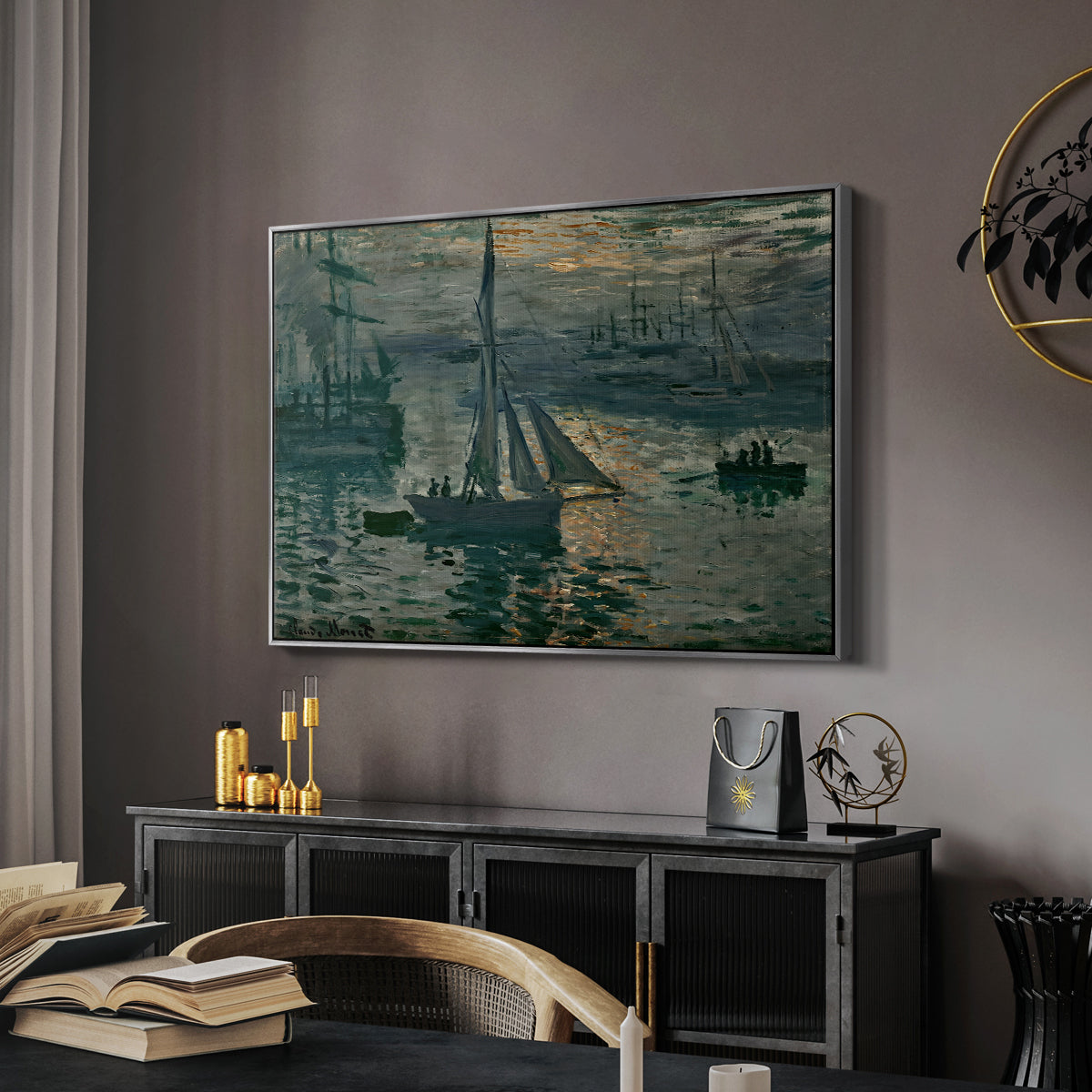 Sunrise (Marine), 1873 by Claude Monet in a silver floater framed canvas featuring an early morning harbor scene with boats and diffused light, displayed above a desk in a dark home office interior.