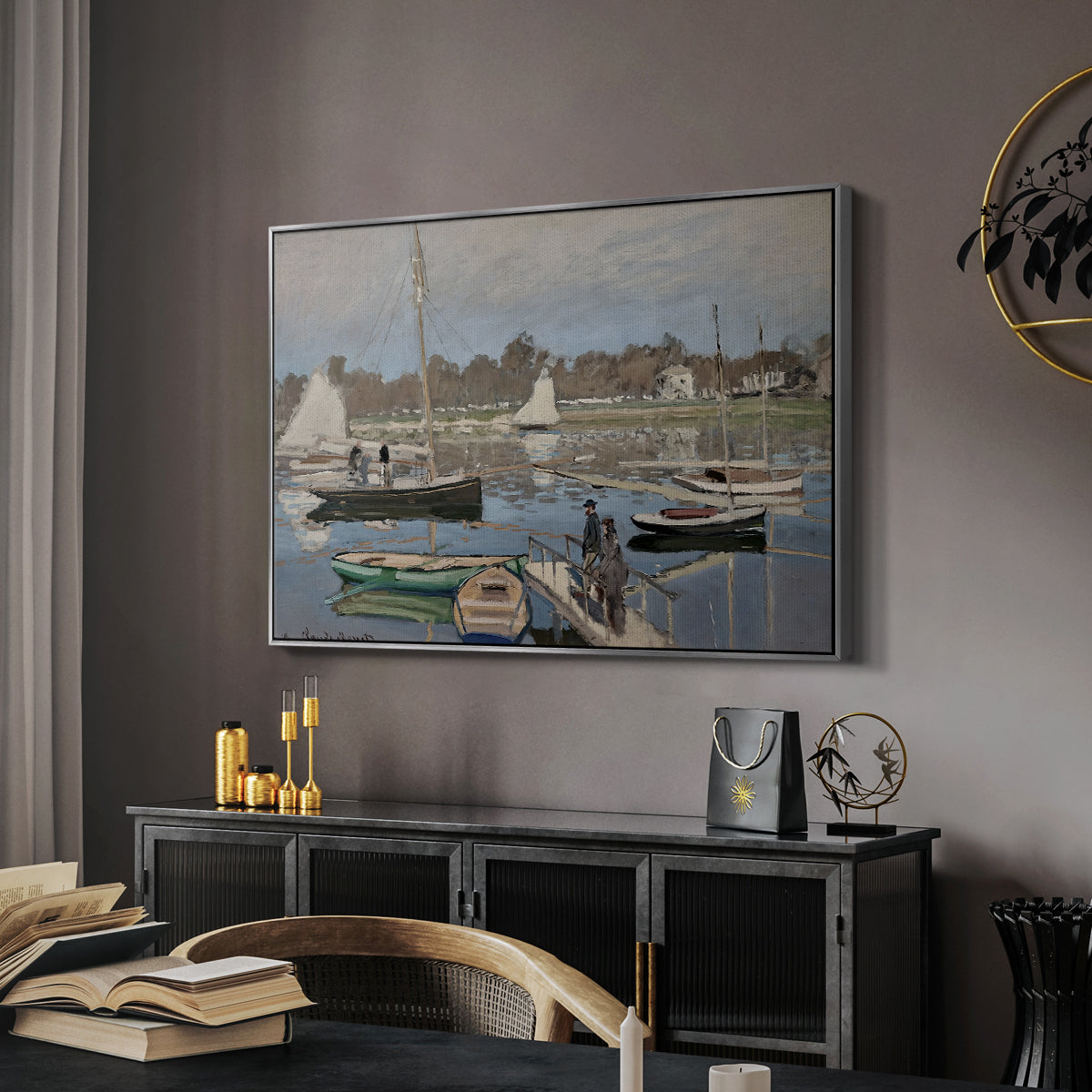 The Basin at Argenteuil, 1874 by Claude Monet in a silver floater framed canvas featuring a harbor basin filled with boats under soft sky, displayed above a desk in a dark home office interior.