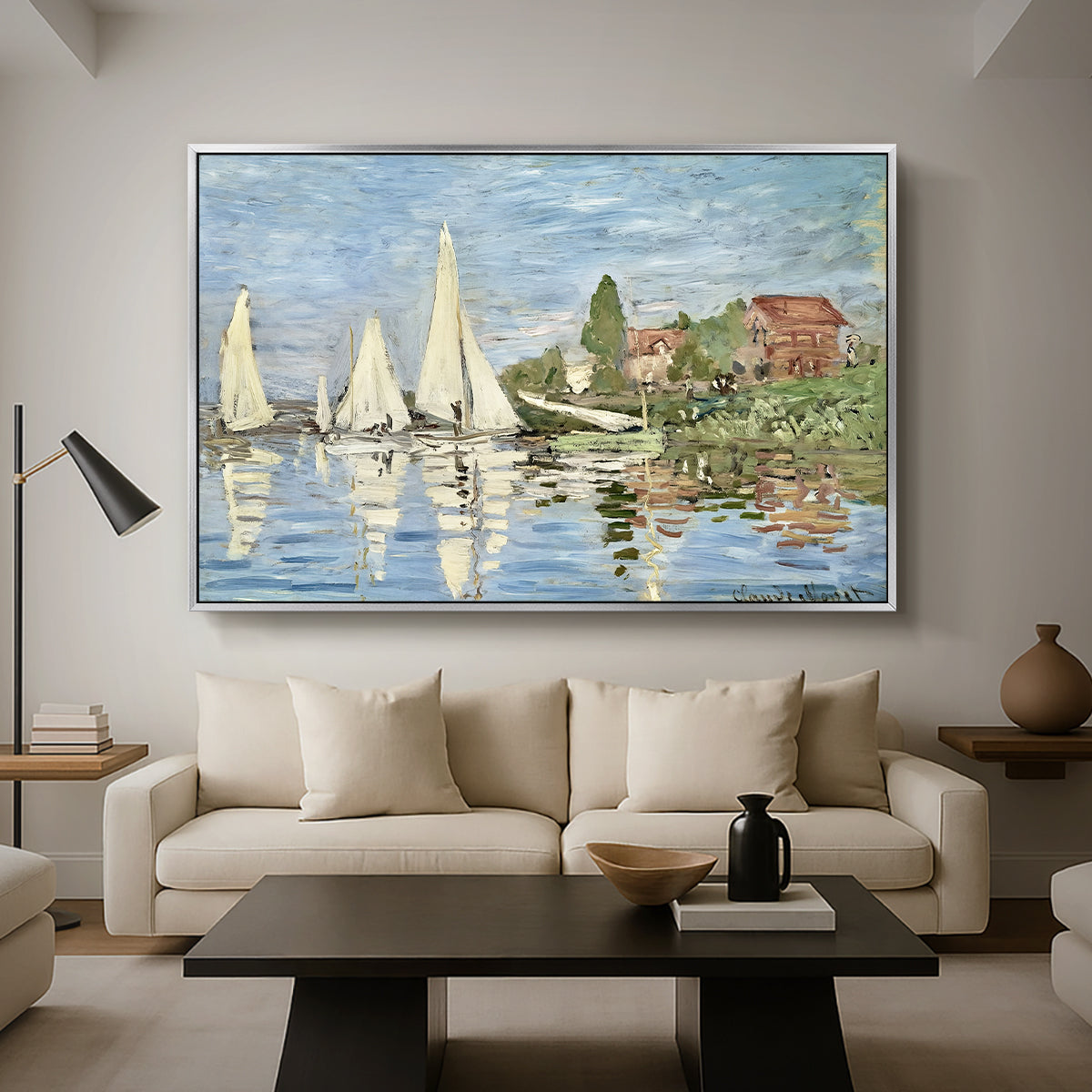 Regatta at Argenteuil, 1872 by Claude Monet as a silver floater framed canvas featuring colorful sailboats racing across river under bright sky, displayed above a sofa in a modern living room.