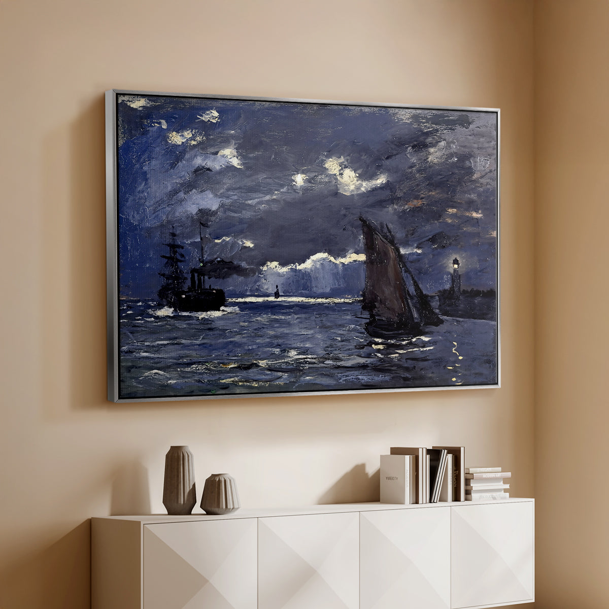 Silver floater framed canvas of A Seascape, Shipping by Moonlight, 1864 by Claude Monet, featuring a nocturnal seascape with boats silhouetted against glowing moon above a console cabinet in a minimalist entryway.