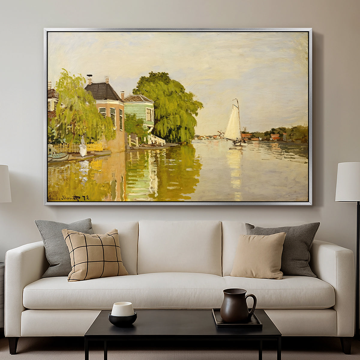 Houses on the Achterzaan, 1871 by Claude Monet displayed in a silver floater framed canvas above a sofa in a clean living room.