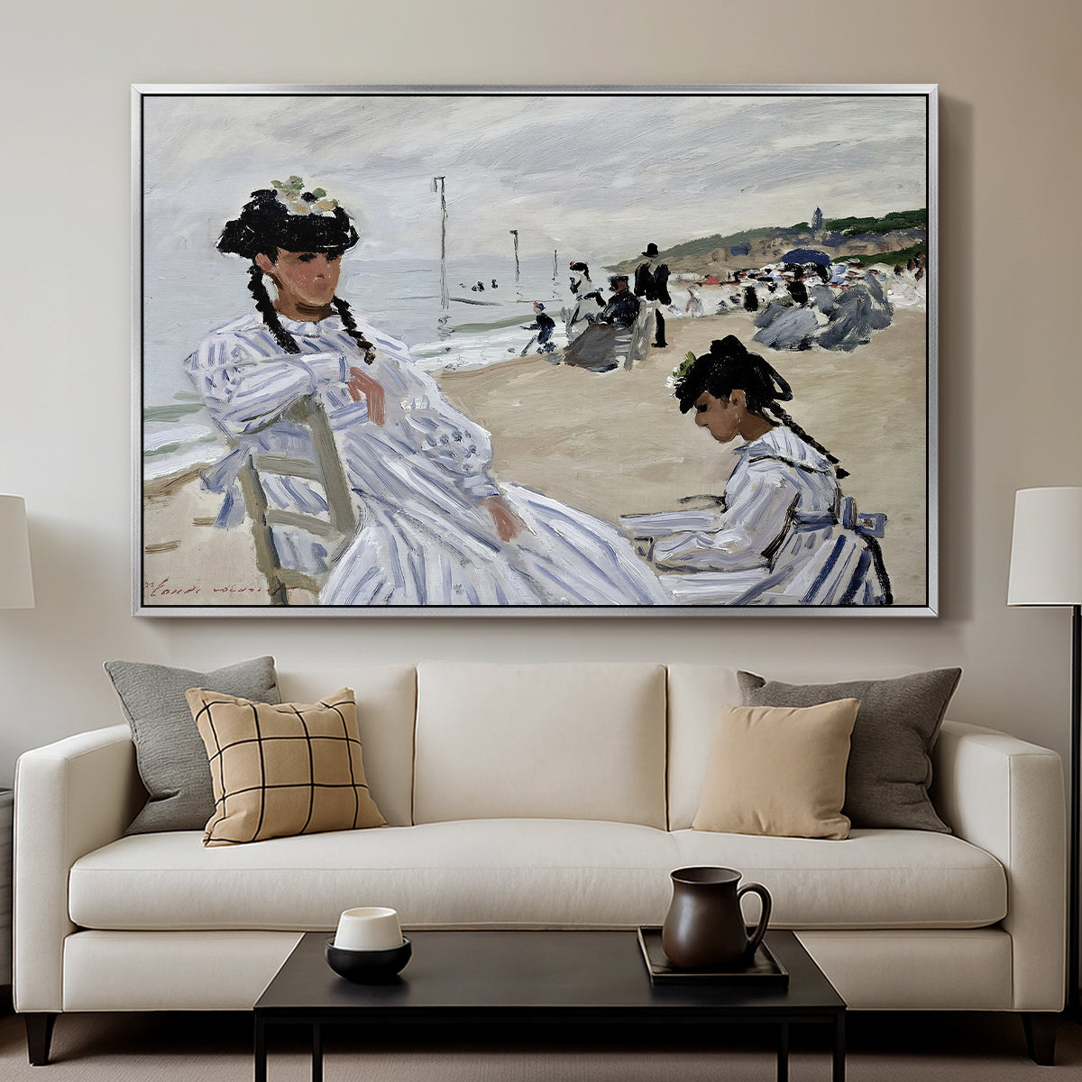 On the Beach at Trouville, 1870 by Claude Monet displayed in a silver floater framed canvas above a sofa in a clean living room.