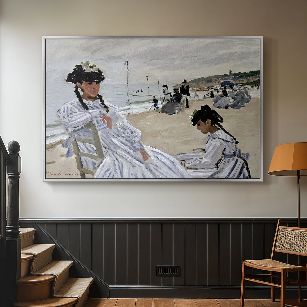 Silver floater framed canvas featuring a coastal leisure scene with figures looking out to sea, displayed in a hallway near a staircase.