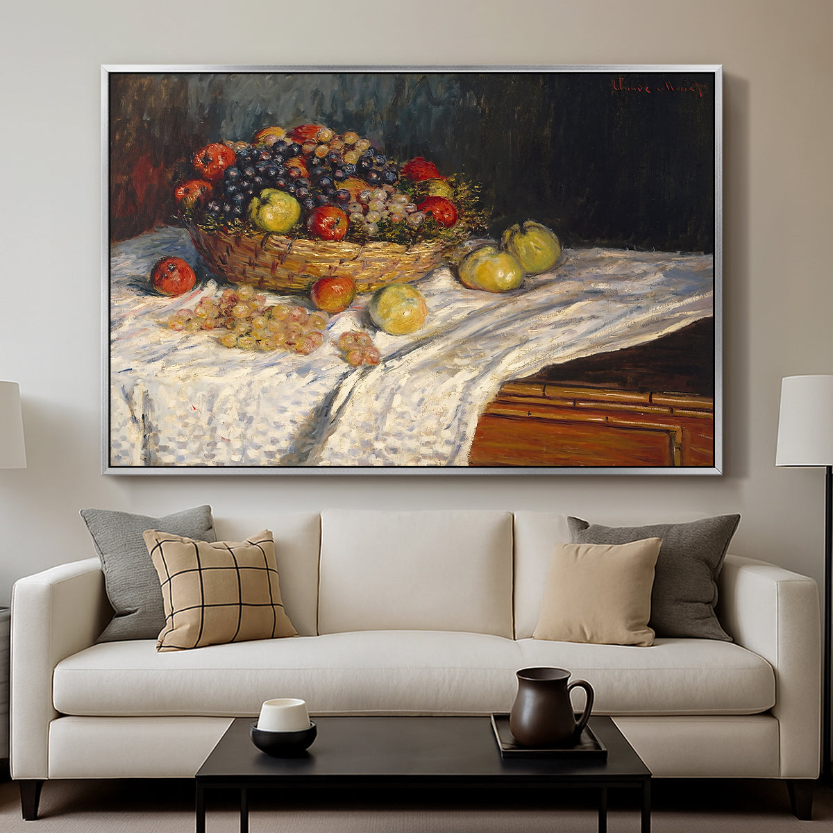 Still Life with Apples and Grapes, 1880 by Claude Monet displayed in a silver floater framed canvas above a sofa in a clean living room.