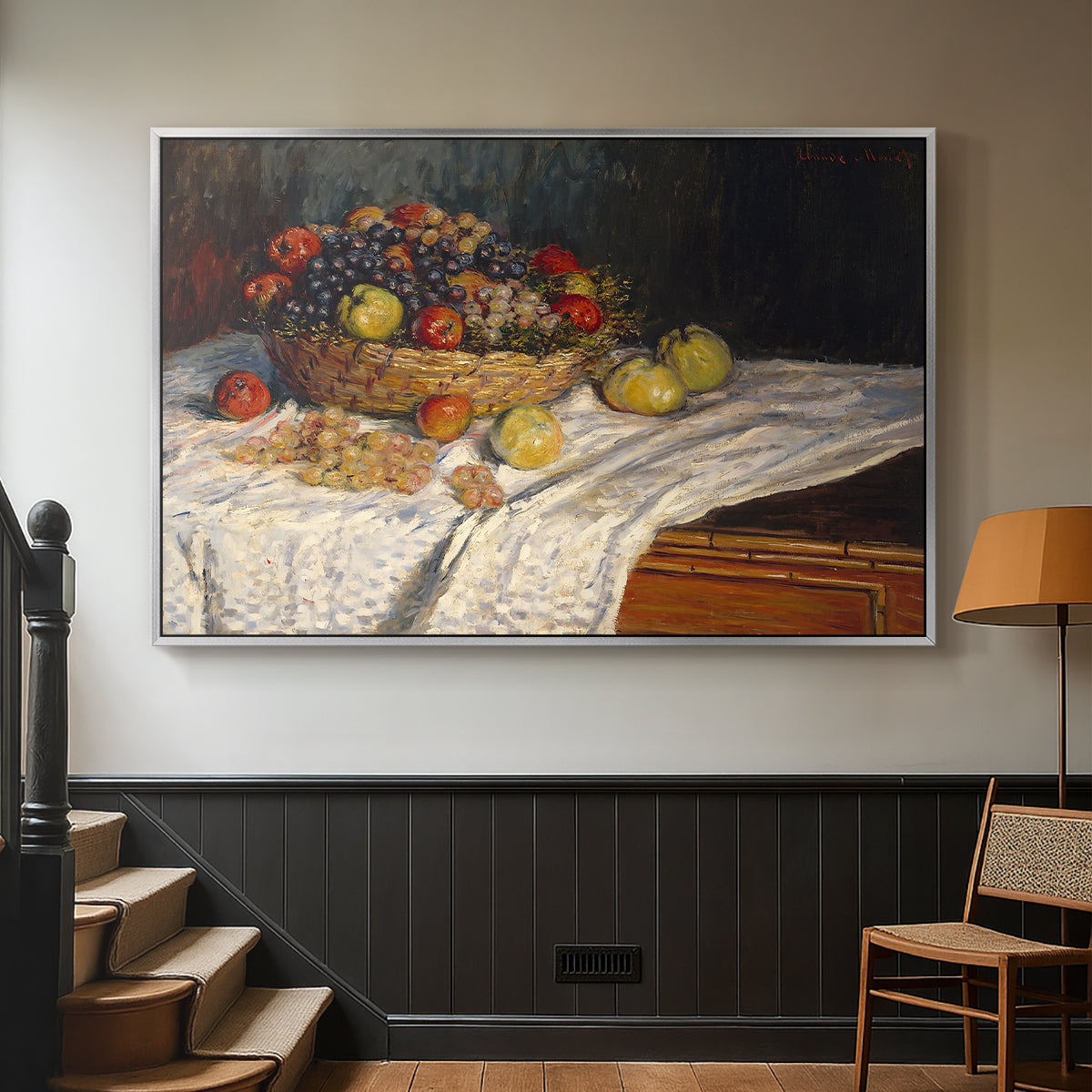 Silver floater framed canvas featuring a tabletop composition with fruit and subtle shadows, displayed in a hallway near a staircase.