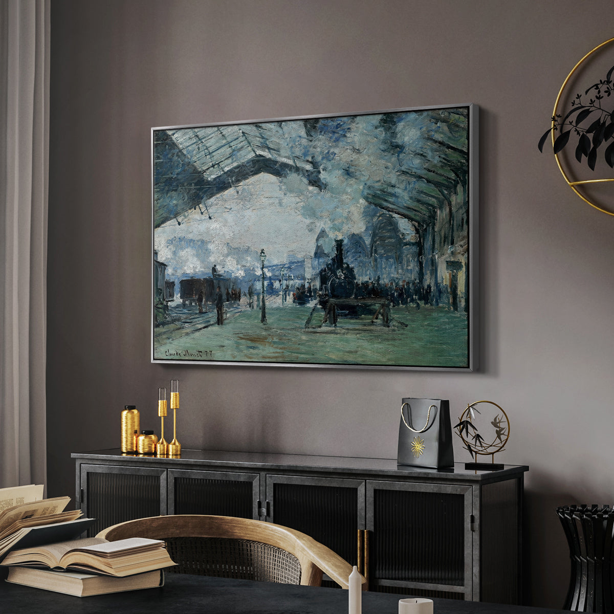 The Saint-Lazare Station, 1877 by Claude Monet in a silver floater framed canvas featuring an interior view of station filled with movement and smoke, displayed above a desk in a dark home office interior.