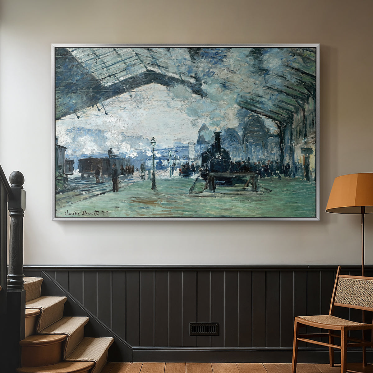Silver floater framed canvas featuring a dramatic depiction of industrial space with trains and light, displayed in a hallway near a staircase.