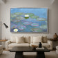 Water Lilies (Nymphéas), 1897-1899 by Claude Monet as a silver floater framed canvas featuring floating water lilies on pond with reflections of sky and foliage, displayed above a sofa in a modern living room.