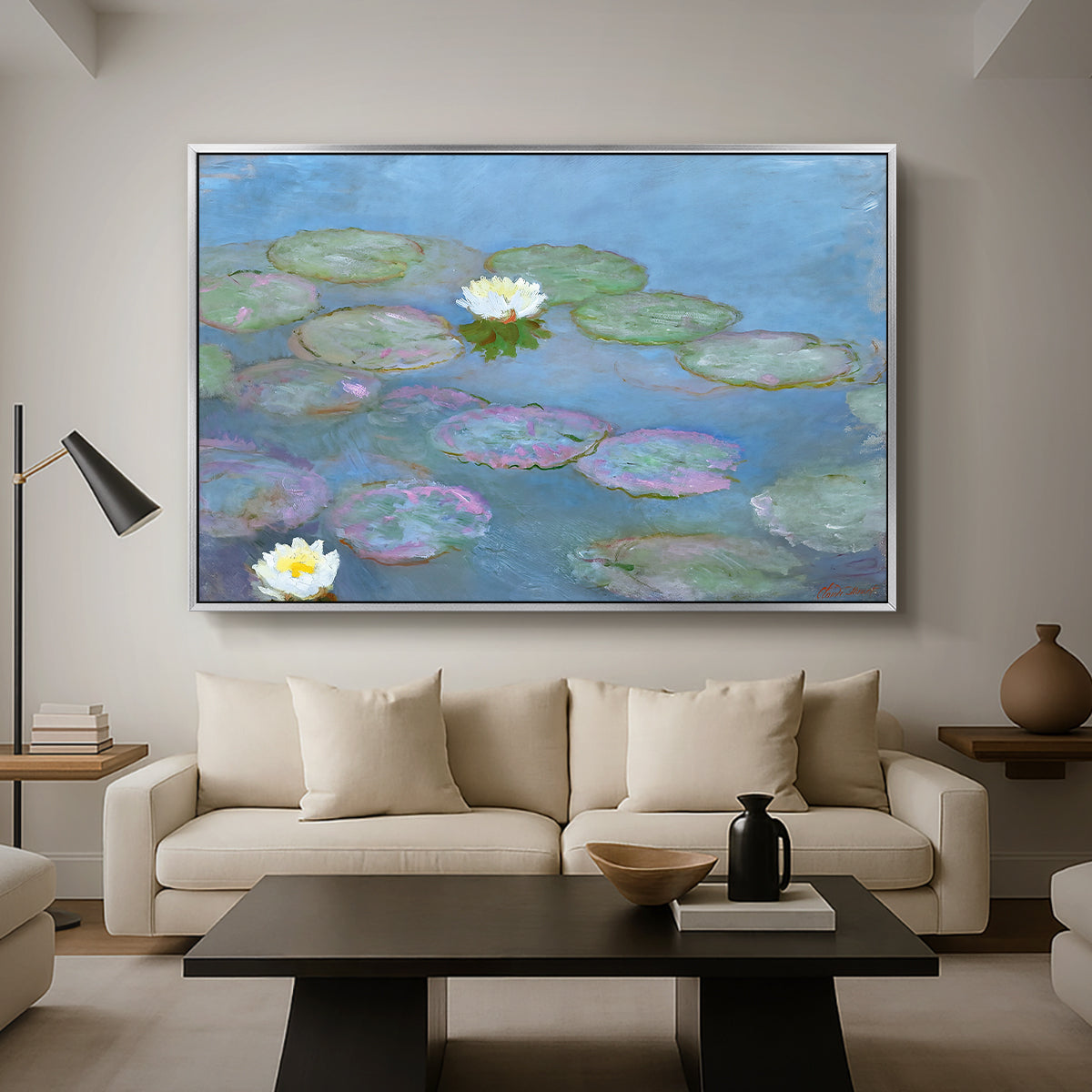 Water Lilies (Nymphéas), 1897-1899 by Claude Monet as a silver floater framed canvas featuring floating water lilies on pond with reflections of sky and foliage, displayed above a sofa in a modern living room.