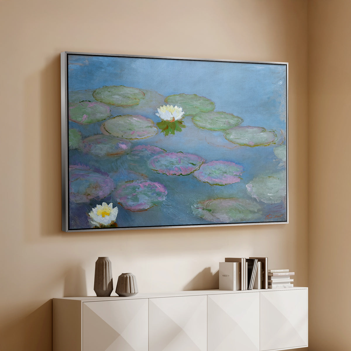 Silver floater framed canvas of Water Lilies (Nymphéas), 1897-1899 by Claude Monet, featuring an impressionist pond scene with lily pads and soft reflections above a console cabinet in a minimalist entryway.