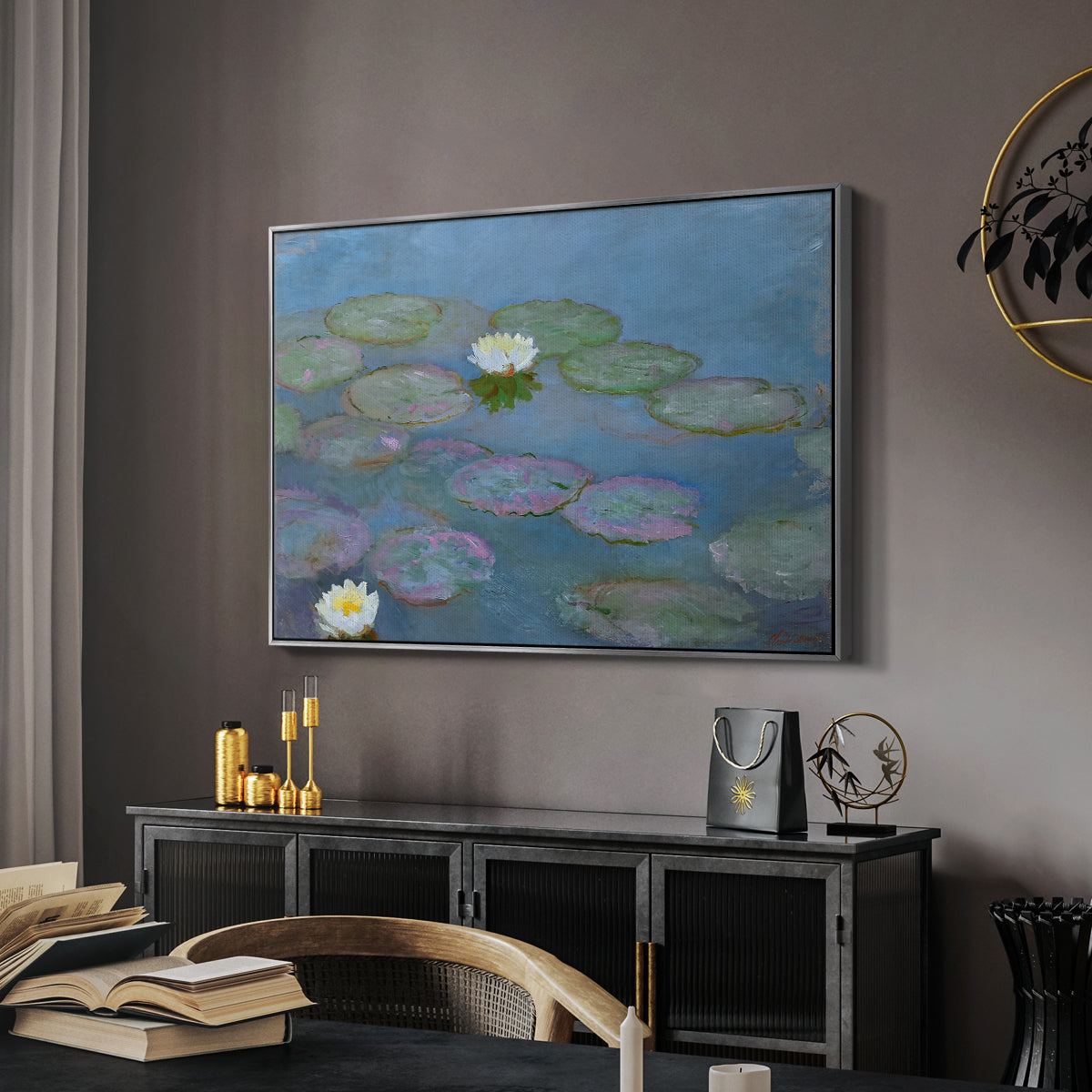 Water Lilies (Nymphéas), 1897-1899 by Claude Monet in a silver floater framed canvas featuring a tranquil water surface covered with blooming lilies, displayed above a desk in a dark home office interior.