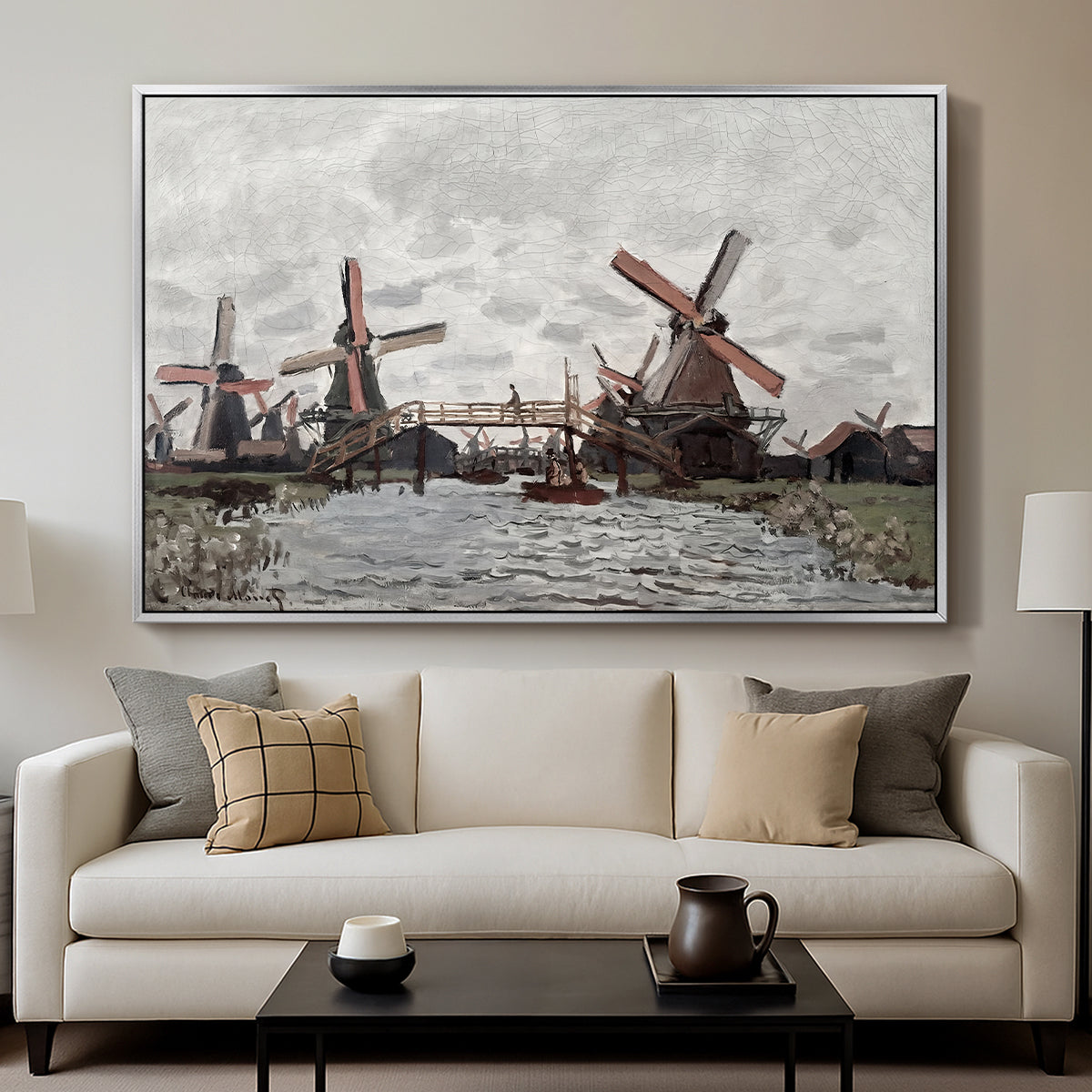 Windmills near Zaandam, 1871 by Claude Monet displayed in a silver floater framed canvas above a sofa in a clean living room.