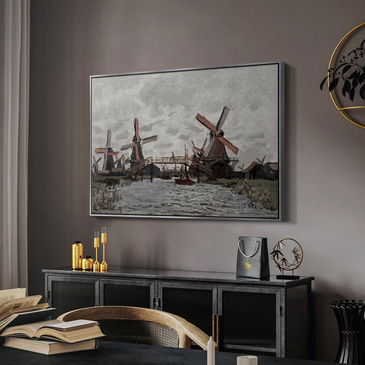 Windmills near Zaandam, 1871 by Claude Monet in a silver floater framed canvas featuring a countryside scene with traditional windmills and reflections, displayed above a desk in a dark home office interior.
