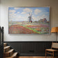 Silver floater framed canvas featuring a rural scene with patterned rows of flowers and windmill, displayed in a hallway near a staircase.