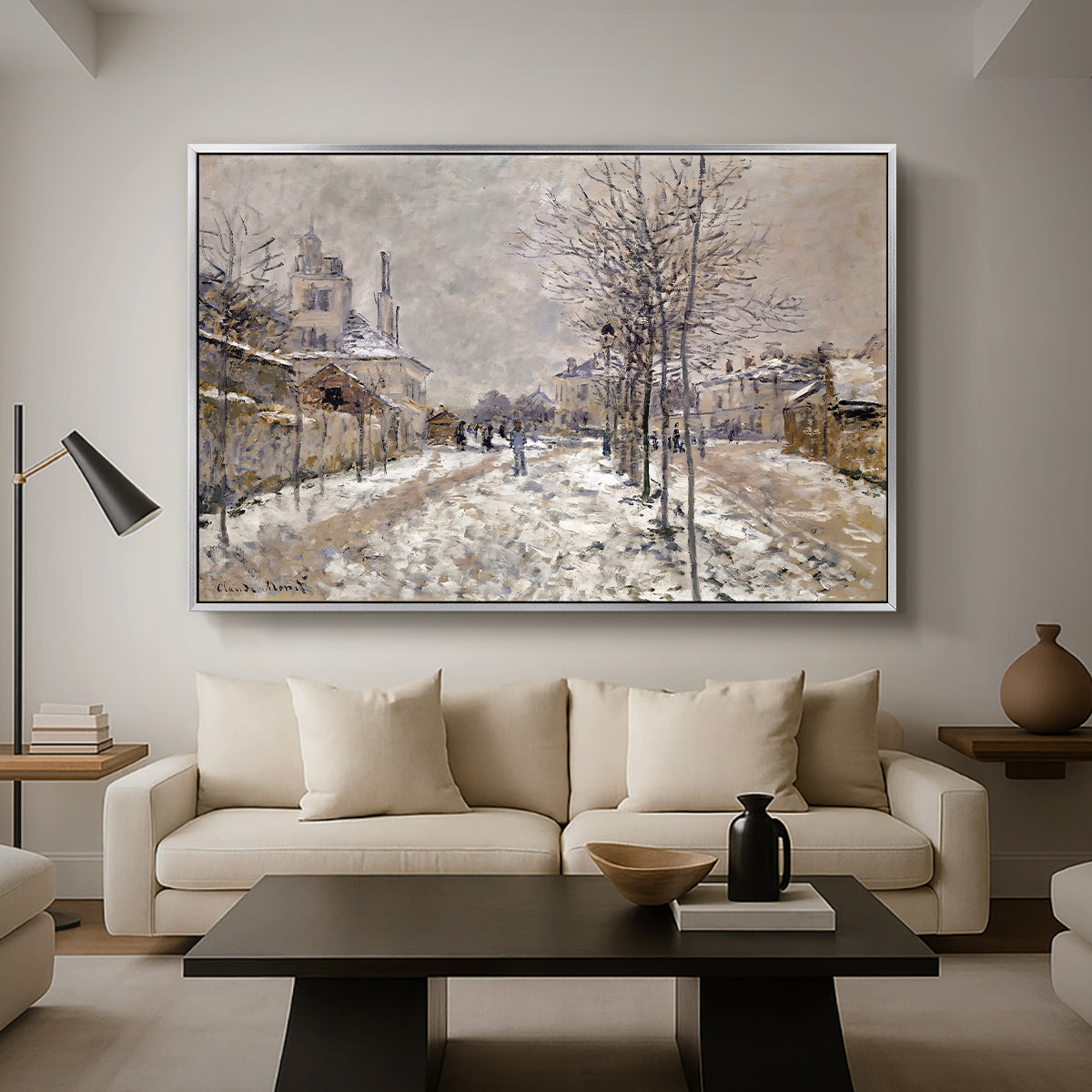 The Boulevard de Pontoise at Argenteuil, Snow Effect, 1875 by Claude Monet as a silver floater framed canvas featuring a snow-covered street lined with trees and buildings under winter sky, displayed above a sofa in a modern living room.
