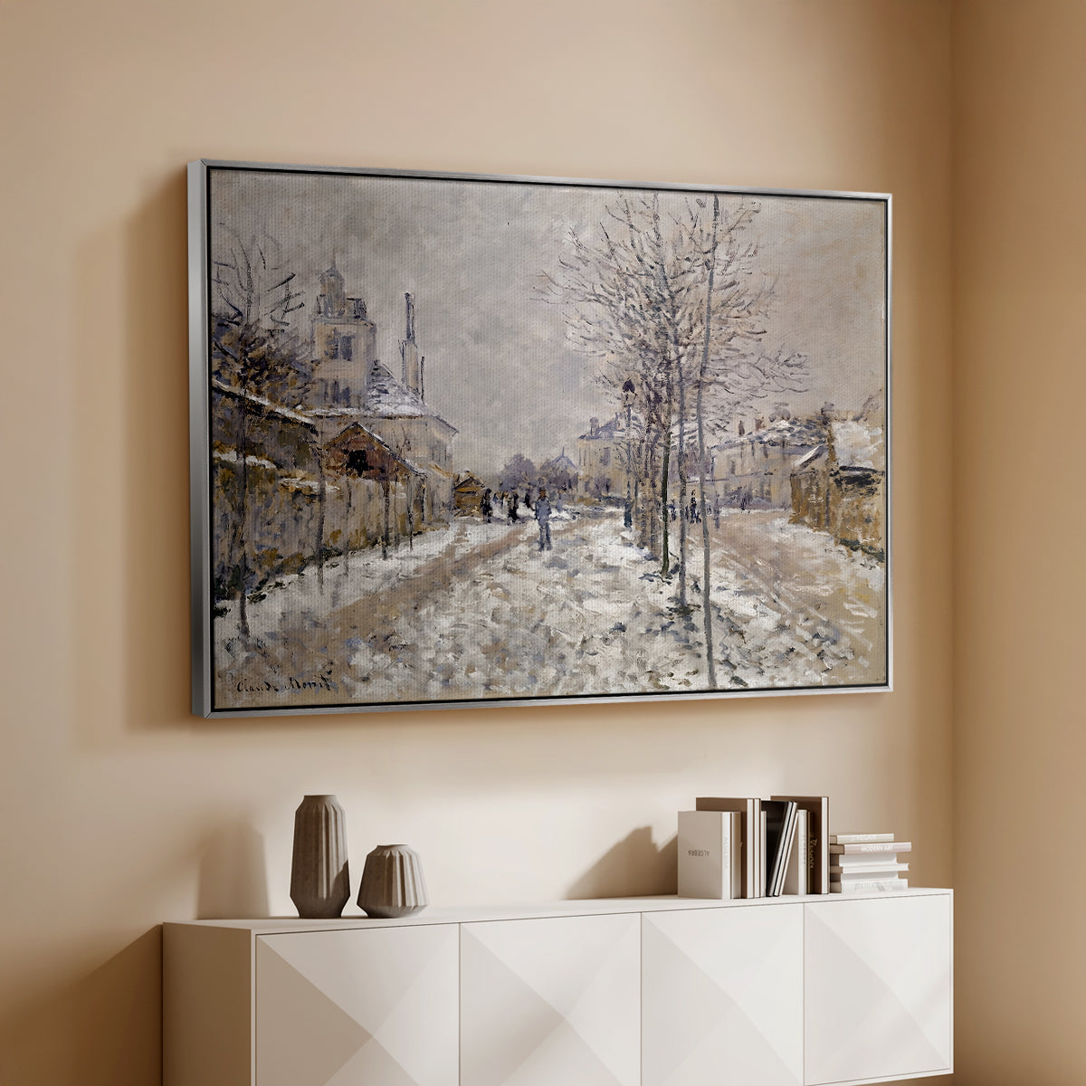 Silver floater framed canvas of The Boulevard de Pontoise at Argenteuil, Snow Effect, 1875 by Claude Monet, featuring an impressionist winter scene with road and bare trees above a console cabinet in a minimalist entryway.
