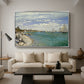 Regatta at Sainte-Adresse, 1867 by Claude Monet as a silver floater framed canvas featuring sailboats gathered near shore with flags and spectators along coastline, displayed above a sofa in a modern living room.