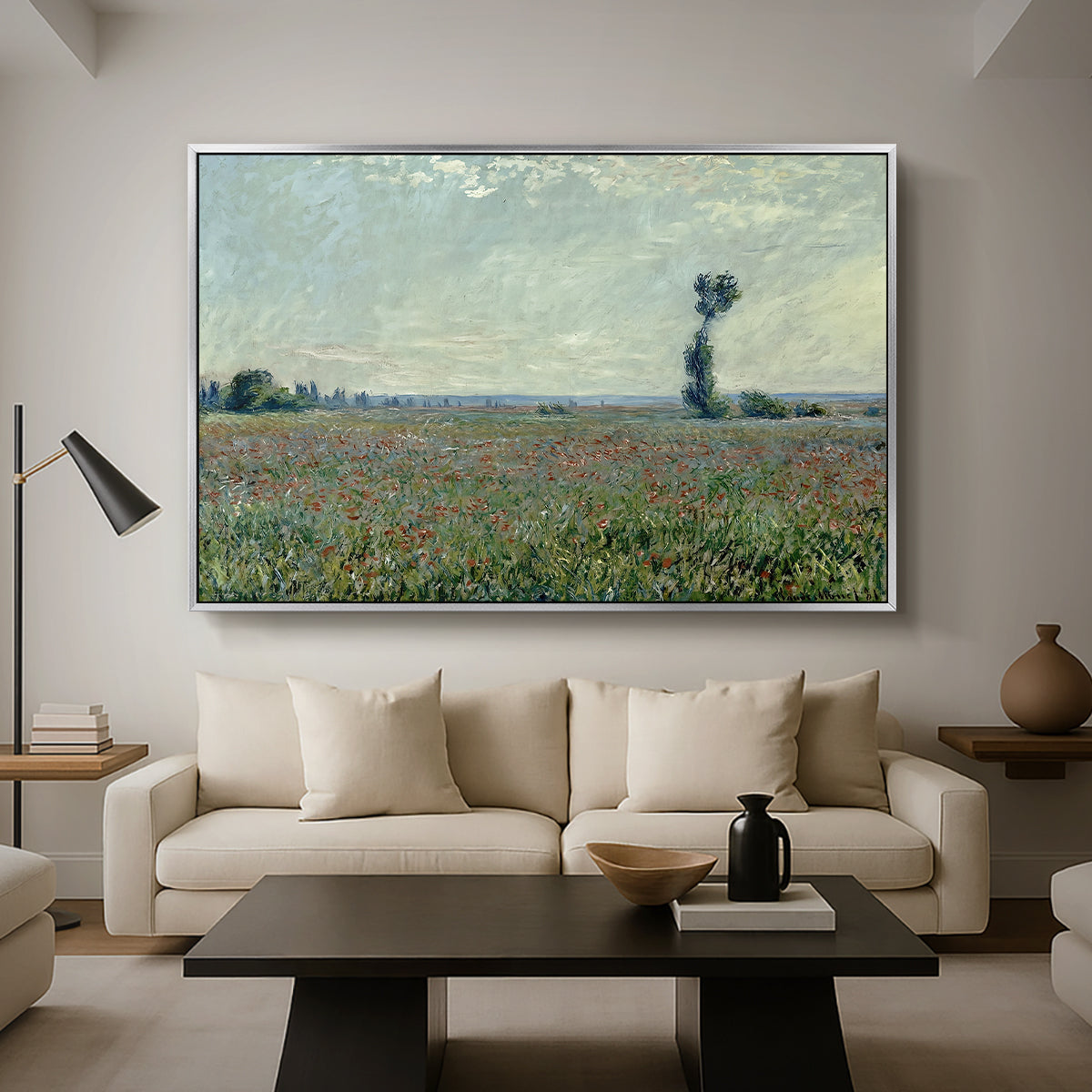 Poppy Field, 1881 by Claude Monet as a silver floater framed canvas featuring a wide field of red poppies stretching across countryside under open sky, displayed above a sofa in a modern living room.