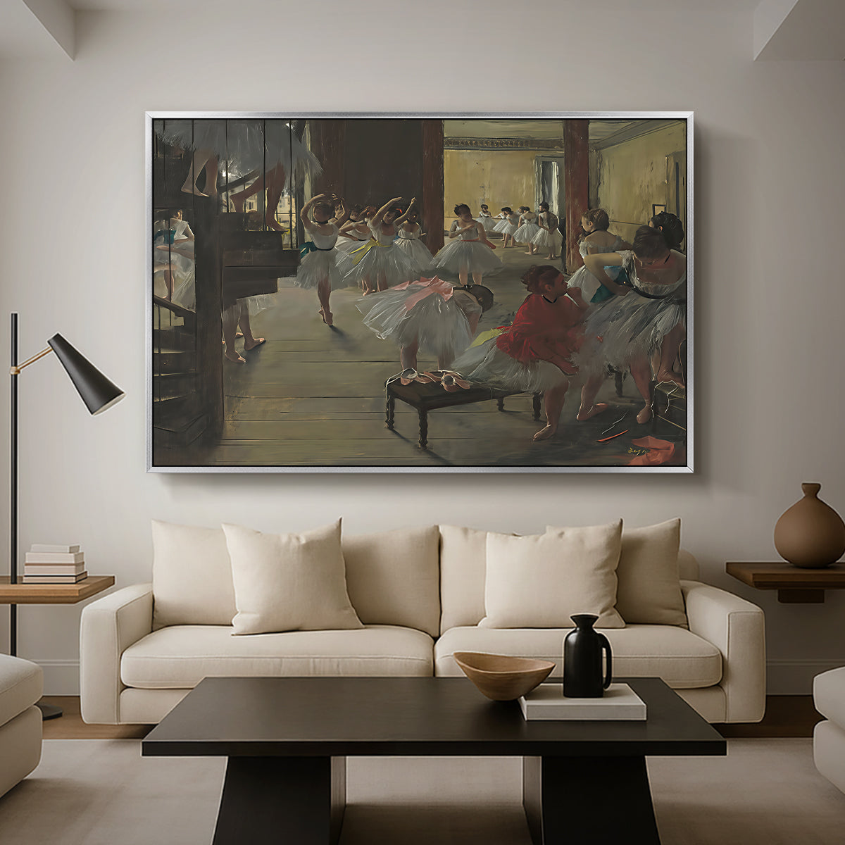The Dance Class, c. 1873 by Edgar Degas as a silver floater framed canvas featuring ballerinas practicing in studio with instructor observing nearby, displayed above a sofa in a modern living room.
