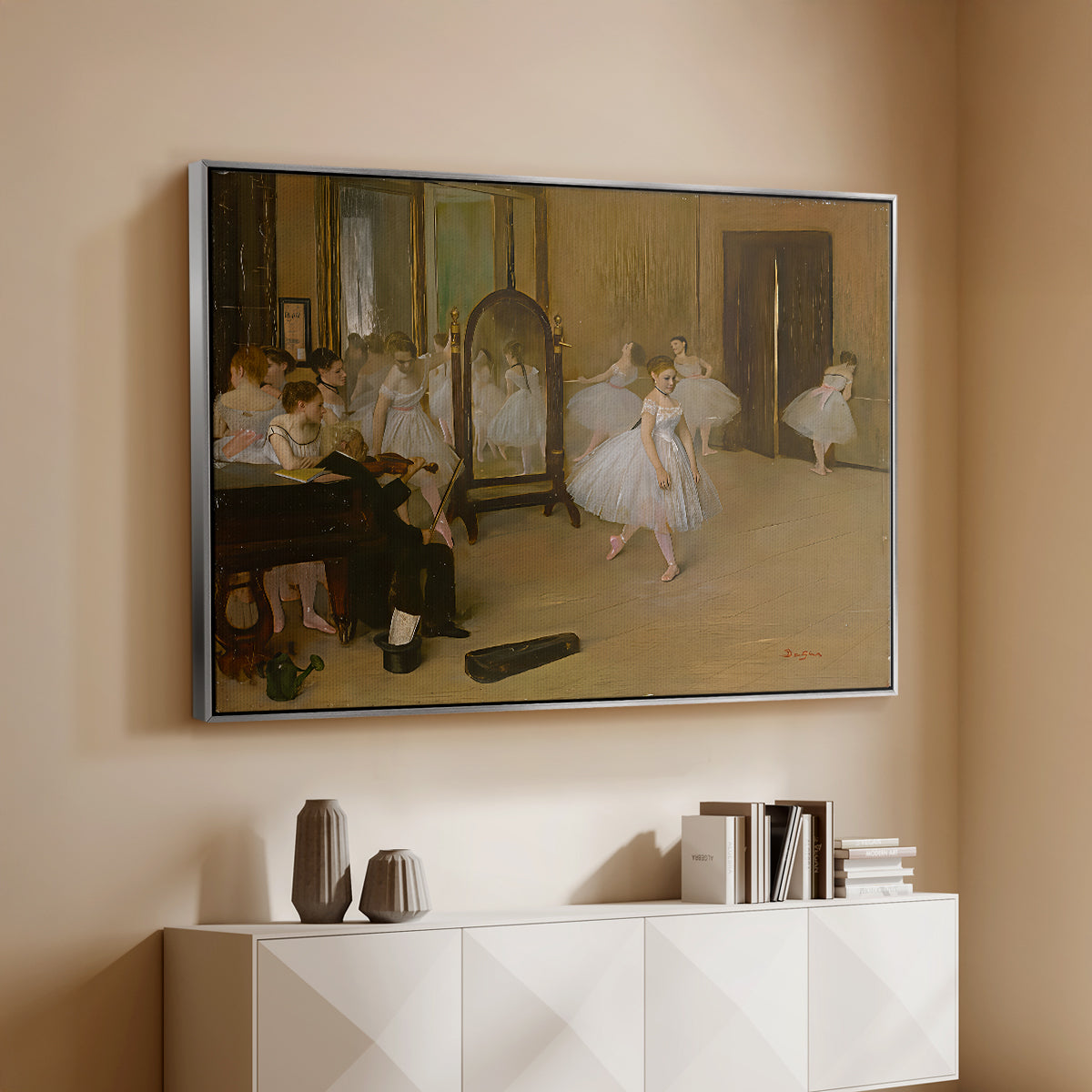Silver floater framed canvas of The Dancing Class, c. 1870 by Edgar Degas, featuring a rehearsal scene with ballerinas in tutus arranged in studio above a console cabinet in a minimalist entryway.